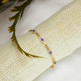 Gold plated bracelet with multiple sapphire blue evil eye charms